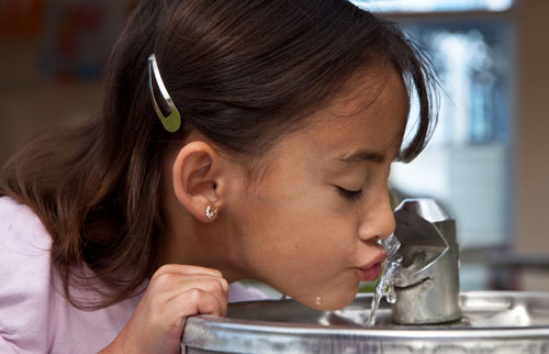 girl drinking from fountain