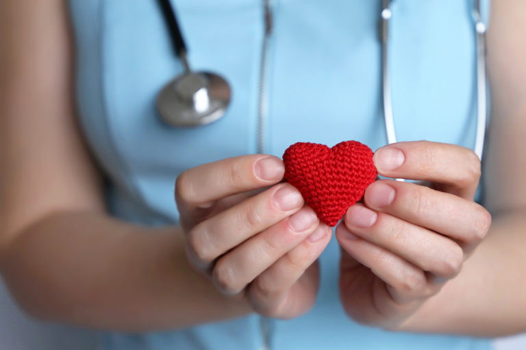 woman doctor holding red heart