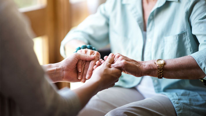 Two women holding both of each other's hands