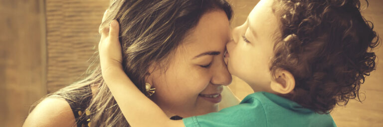 Toddler kissing mom on the forehead